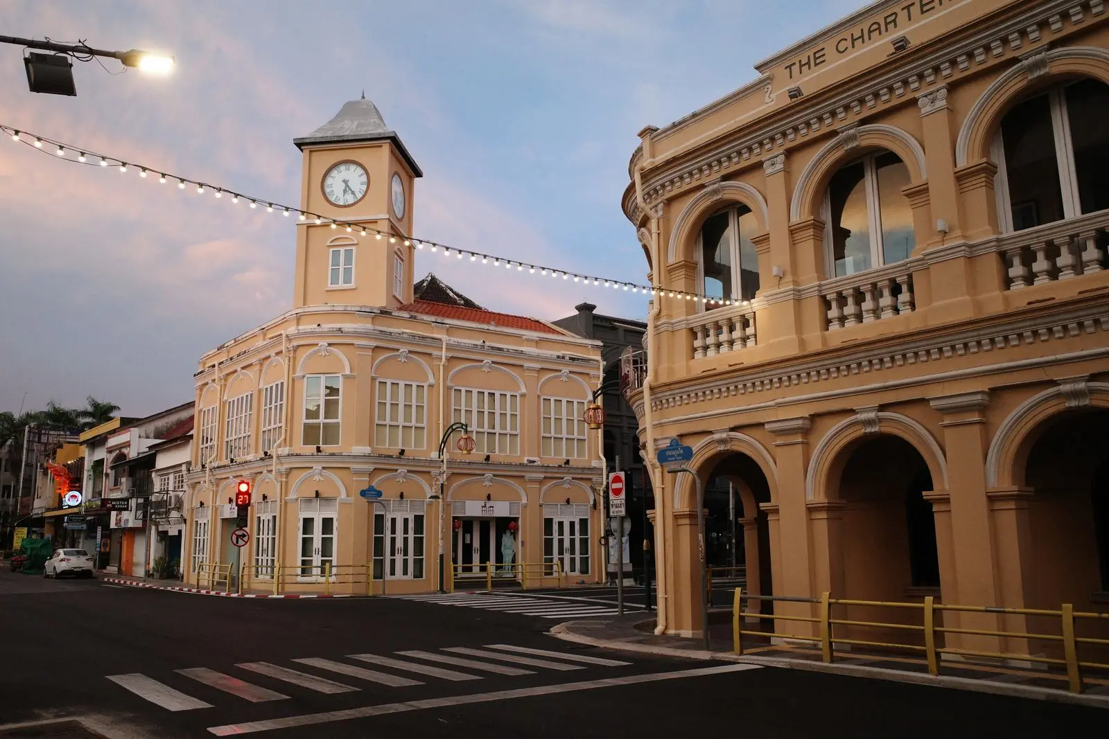 Colonial shophouses and the clock tower in Phuket Town at dusk