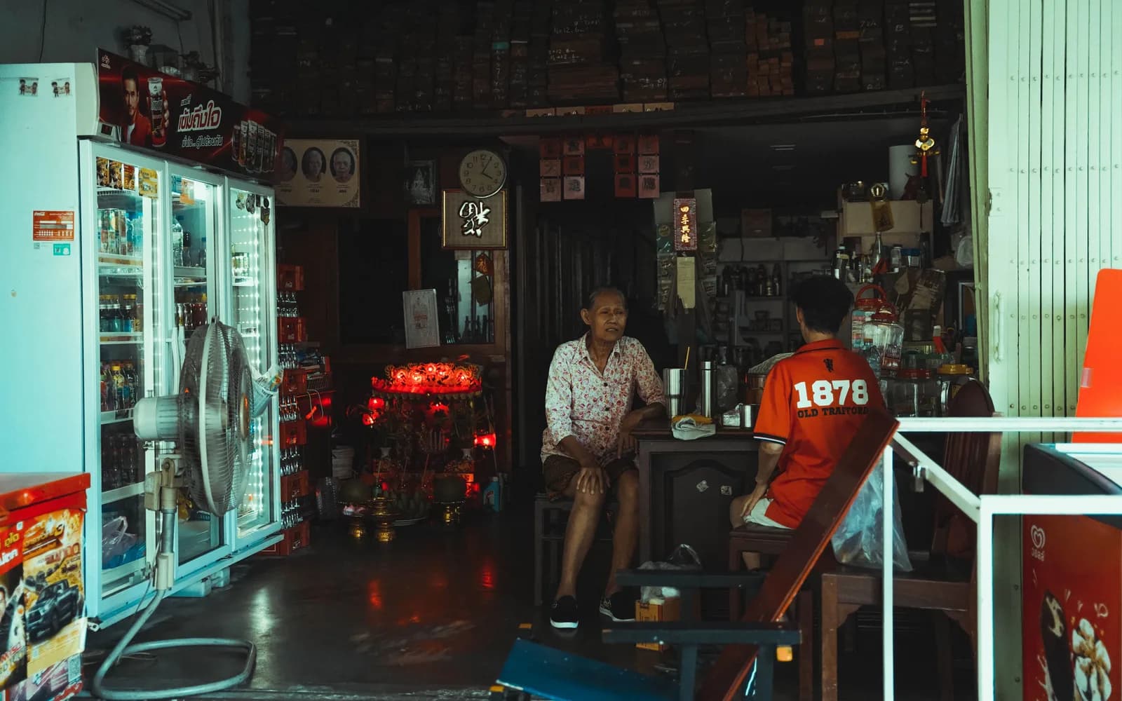 Two men in conversation inside a café in Thailand