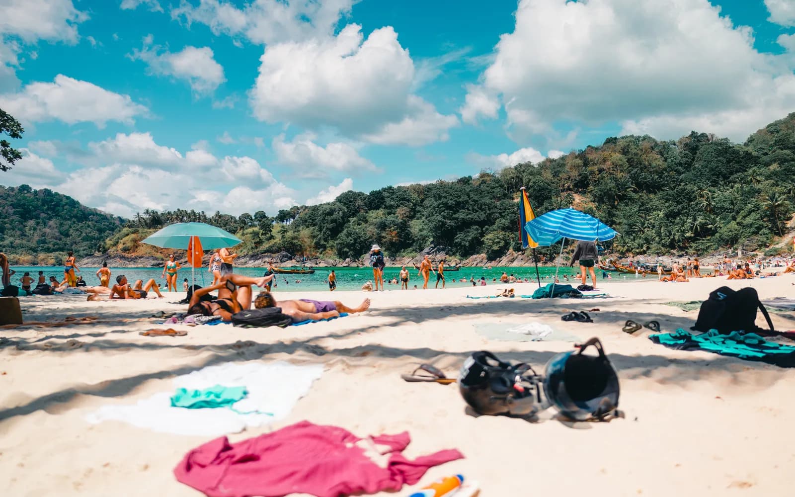 A busy beach day in Phuket with sunbeds along the sand