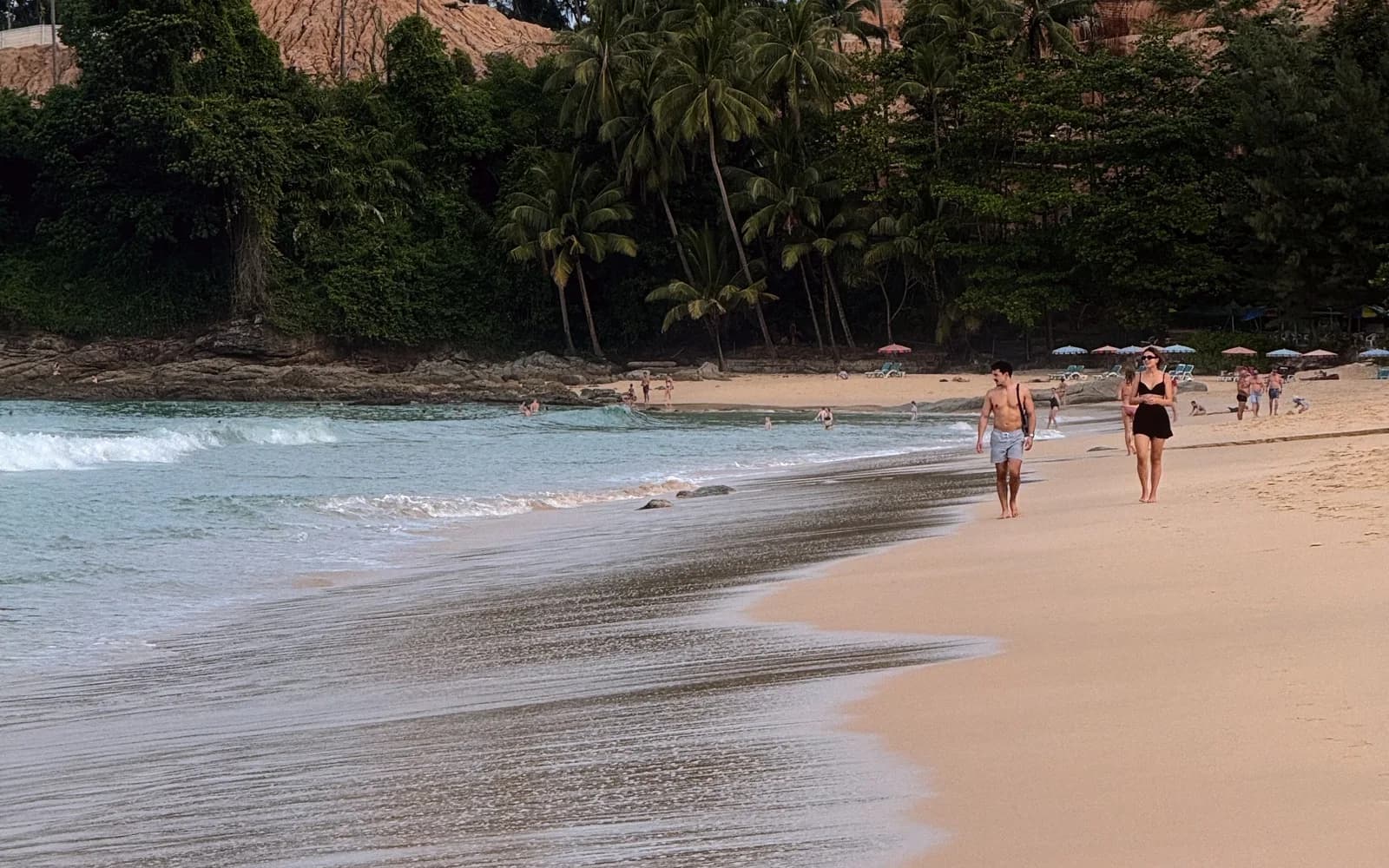 Beach in Phuket with lush greenery running down to the sand