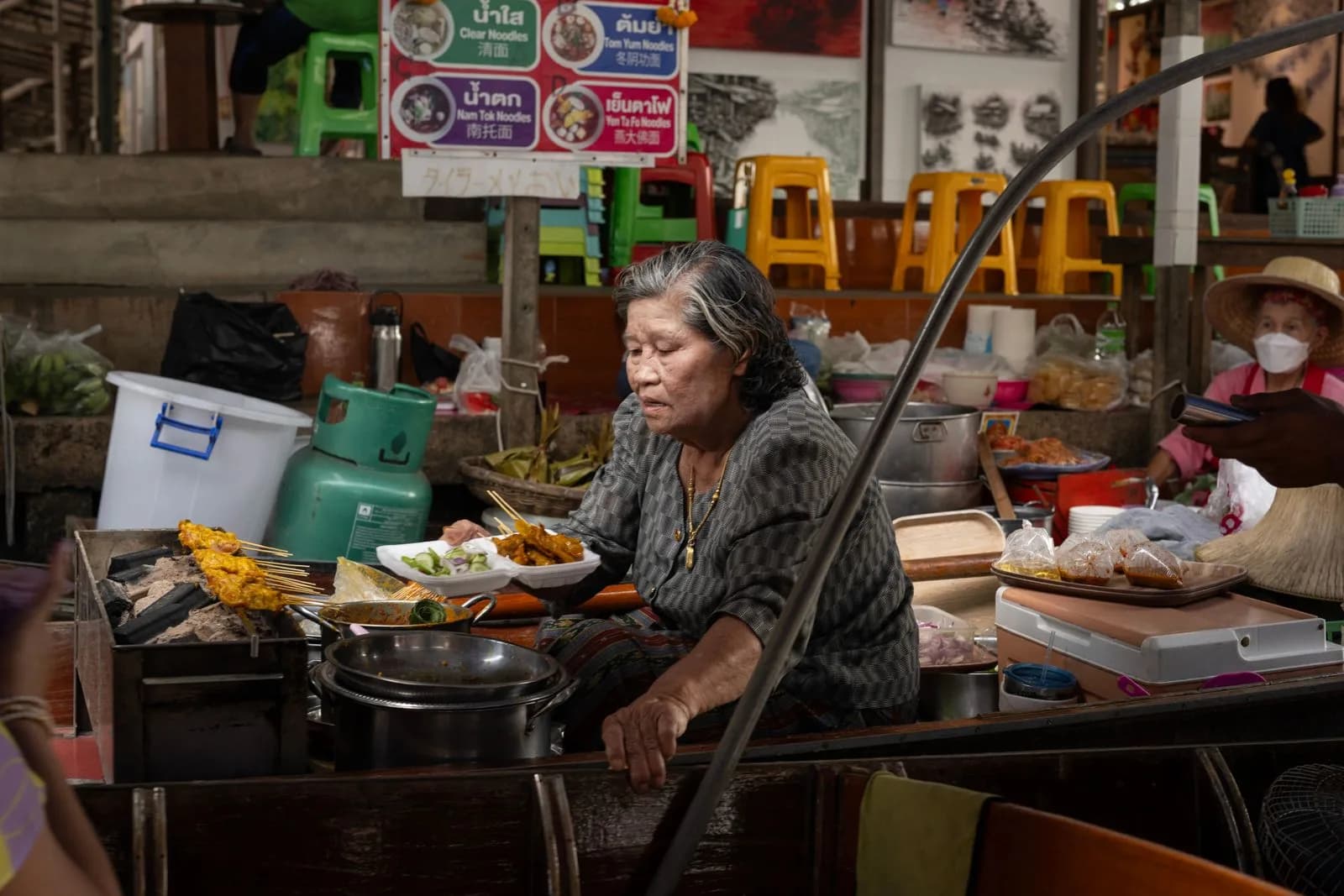 A Thai street food vendor cooking at a stall